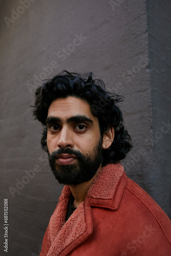Portrait of an asian man with curly hair and beard. Concept of gen z, fashion and self expression.