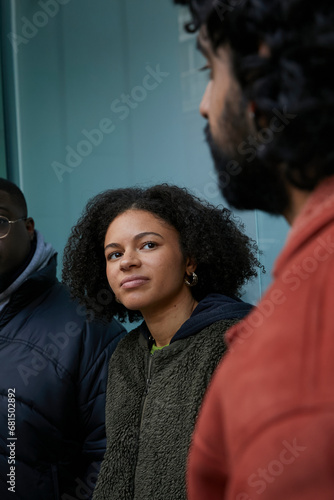Three friends having a chat outside wearing warm stylish coats. Concept of gen z, fashion and self expression