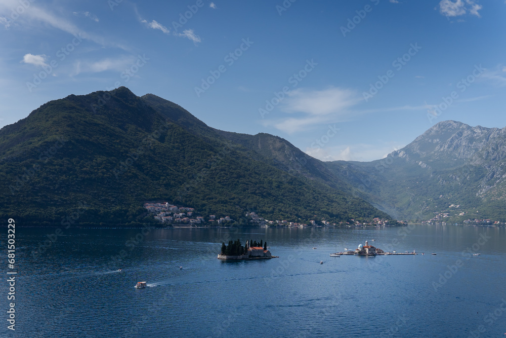 Boats sail among the mountains and the sea