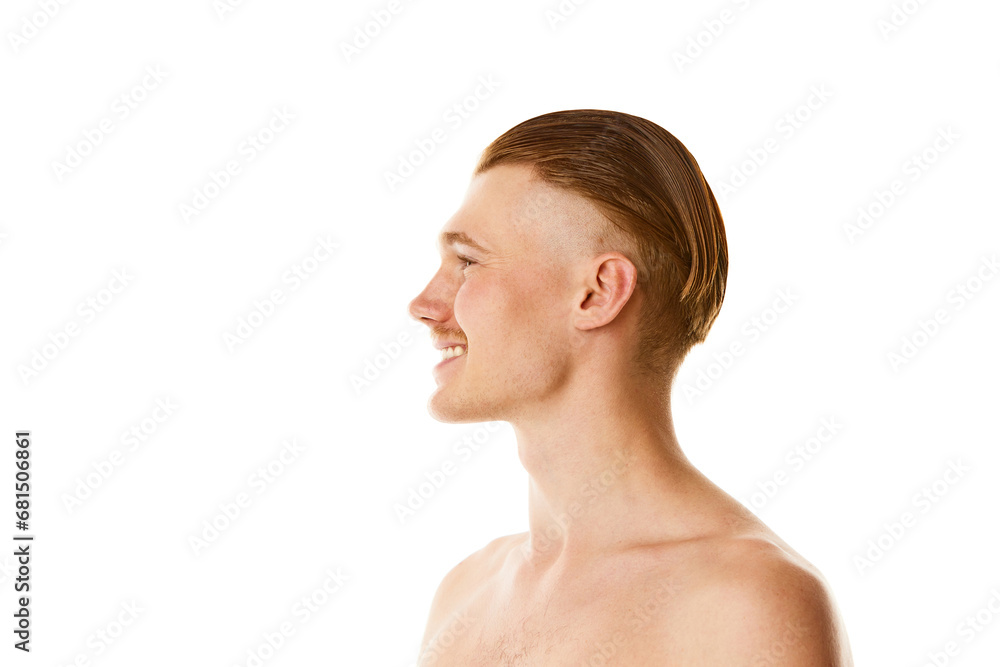 Side view close up portrait of young attractive smiling man with red hair and stylish haircut against white studio background.