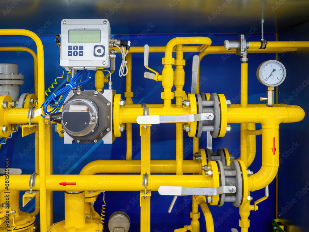 Gas infrastructure. Yellow pipes inside metal cabinet. Gas compressor unit. Pipes with mechanical and electronic sensors. Gas unit for supplying factory with propane. Gasification of premises
