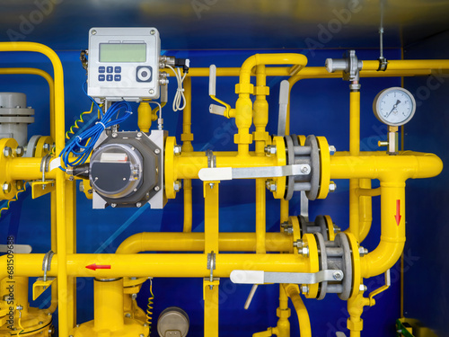 Gas infrastructure. Yellow pipes inside metal cabinet. Gas compressor unit. Pipes with mechanical and electronic sensors. Gas unit for supplying factory with propane. Gasification of premises