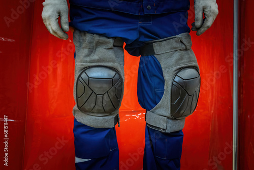 Protective knee pads on worker legs. Uniforms for industrial safety. Knee pads to protect legs of factory staff. Production uniforms. Protective knee pads on cropped construction worker