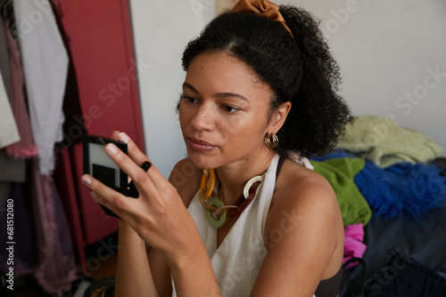 Stylish woman retouches makeup before her friend photographs her for social media content. Concept of gen z, fashion and self expression.