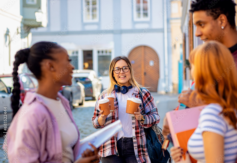 Diverse group of students talking outside during a coffee break at the university. Diverse group of students talking outside during a coffee break at the university.