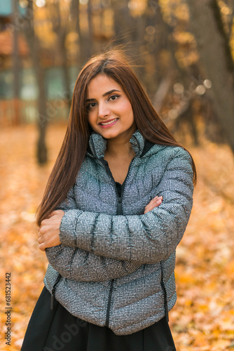Close-up portrait of diversity young beautiful confident Indian Asian woman in fall outdoor. Happy and natural smiling female. Generation z and gen z youth concept