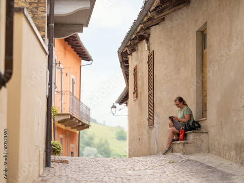 Woman resting in narrow alley in old town photo