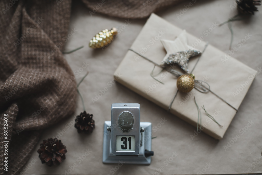 Christmas composition. New Year eve. December 31 on calendar on a craft paper background with spruce branches and a glowing garland. New year's date. Flat lay, top view Christmas composition. New Year eve. December 31 on calendar on a craft paper background with spruce branches and a glowing garland. New year's date. Flat lay, top view