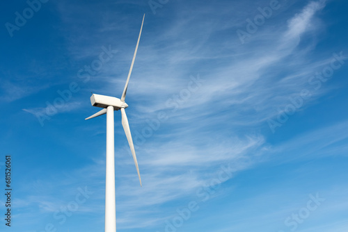Wind turbine against blue sky photo