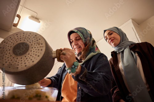 Mother and daughter cooking together for eid al-fitr at home photo