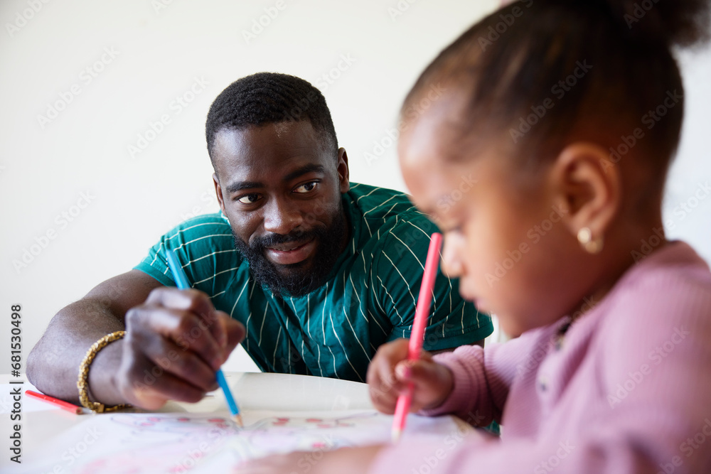 Father and daughter drawing together at home Father and daughter drawing together at home
