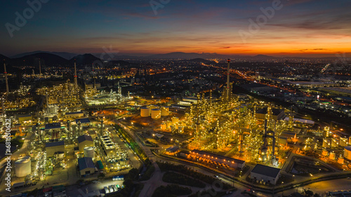 Aerial view of the morning of the oil refinery from the drone of the tower of the Petrochemistry industry in the oil​ and​ gas​ ​industry with​ cloud​ sun orange​ © chitsanupong