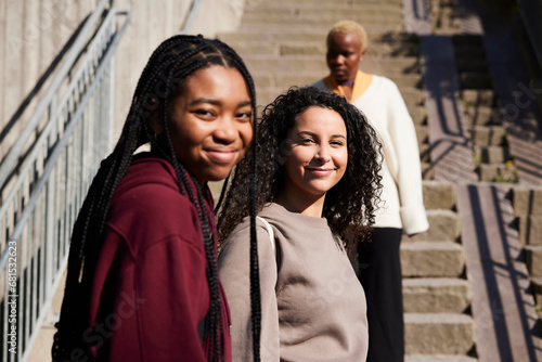 Portrait of happy young multiracial friends against staircase photo
