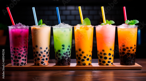 Set of tasty bubble tea in plastic cups on dark background. Various multicolored iced bubble tea. Refreshing summer drink drink. Takeaway drinks with drinking straw photo
