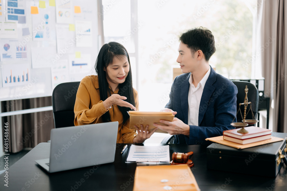 Asian business people and lawyers discussing contract papers sitting at the table. Concepts of law, advice, legal services Asian business people and lawyers discussing contract papers sitting at the table. Concepts of law, advice, legal services