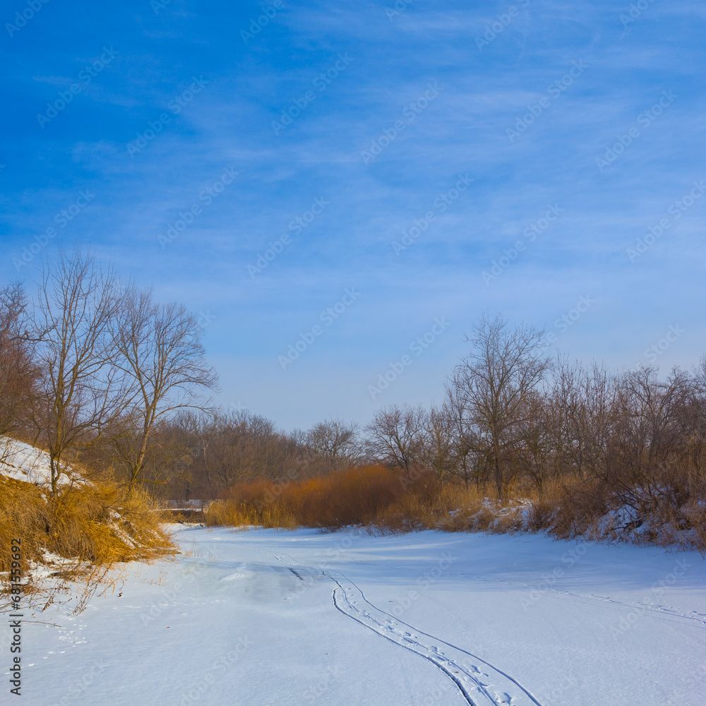 Obraz premium frozen winter river under a blue cloudy sky