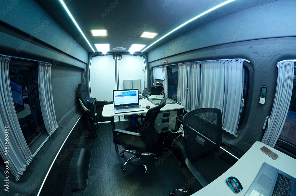 Obraz premium Mobile state administrative services office set in the interior of mini bus: laptops, monitors, phones, printer and other office devices