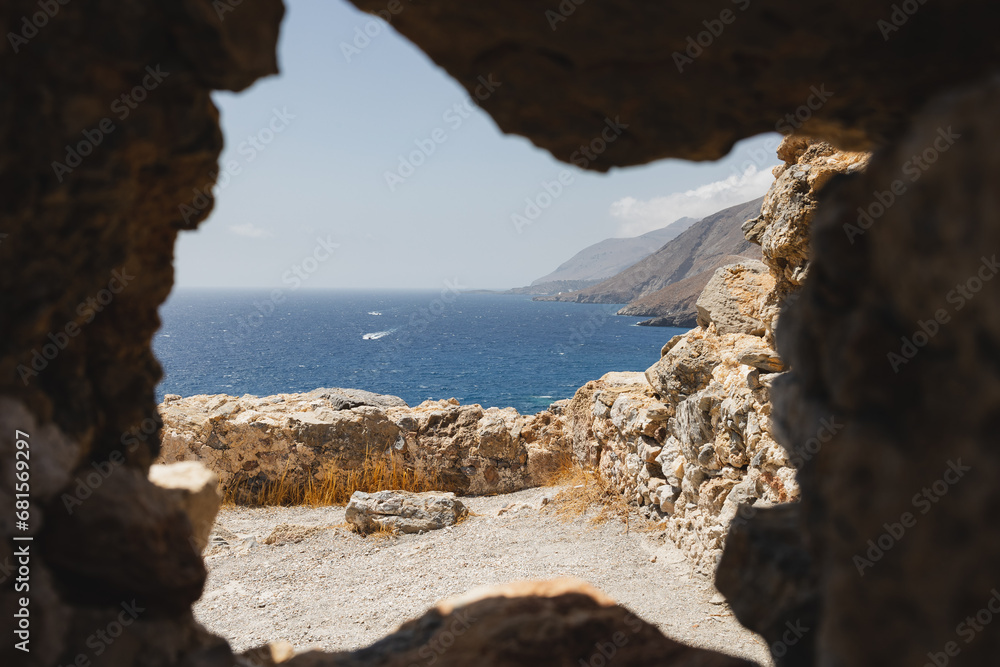 Obraz premium Crete coastline through a ruin, Greece