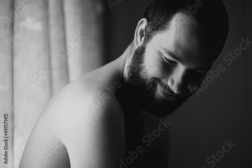 Creativity, man and smile in a bedroom at home with monochrome and black and white. Shy male person, calm thinking and art in the morning in a house with happy memory and relax with solitude photo