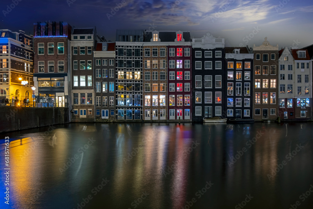 Traditonal houses at the Damrak in Amsterdam in the Netherlands by night