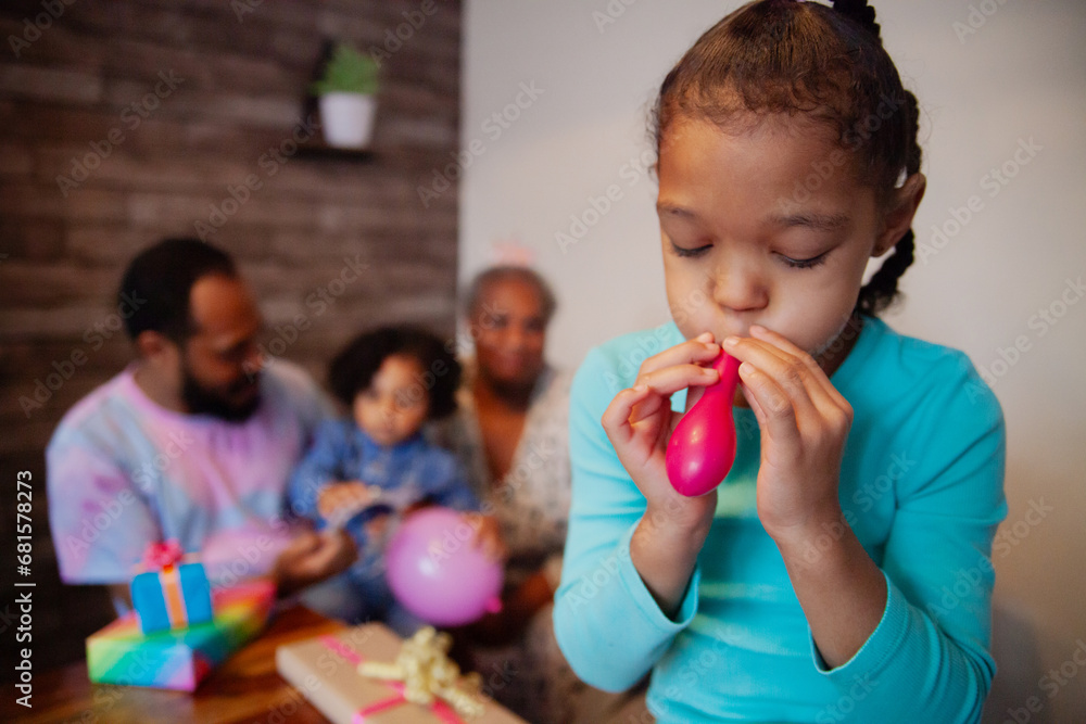 Little biracial girl blowing up birthday balloons Little biracial girl blowing up birthday balloons