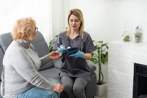 Health visitor and a senior woman during home visit © Angelov