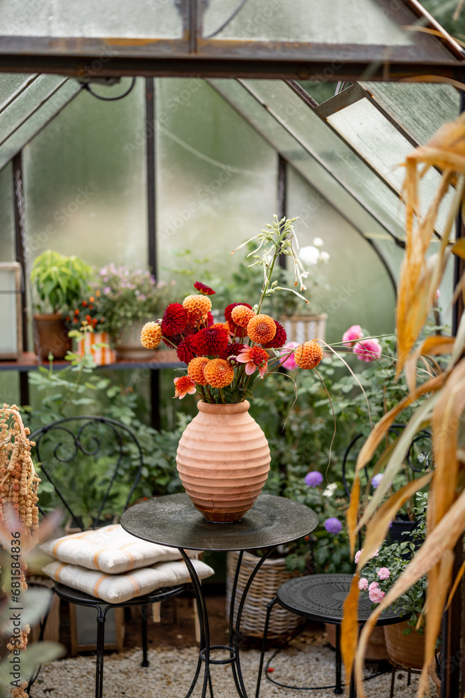 Beautiful vintage greenhouse decorated for an Autumn with orange bouquet of flowers. Concept of decoration, Thanksgiving holiday and gardening