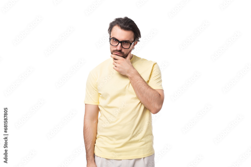 young smart brunette man in a t-shirt and glasses on a white background with copy space young smart brunette man in a t-shirt and glasses on a white background with copy space