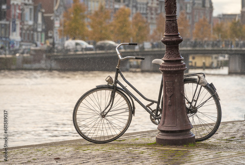 Old dutch bike by the canal in Amsterdam on a rainy autumn day