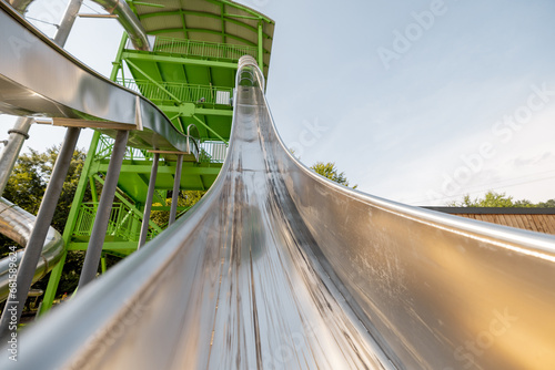 Fototapeta Naklejka Na Ścianę i Meble -  Children's slide made of stainless steel in the amusement park, view from below