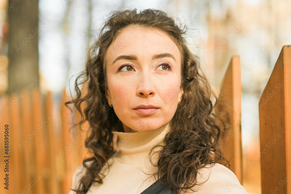 Autumn portrait of a beautiful happy curly woman in fall season. Millennial generation female. Natural beauty concept Autumn portrait of a beautiful happy curly woman in fall season. Millennial generation female. Natural beauty concept