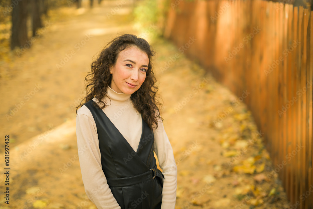 Autumn portrait of a beautiful happy curly woman in fall season copy space mockup. Millennial generation female. Natural beauty concept Autumn portrait of a beautiful happy curly woman in fall season copy space mockup. Millennial generation female. Natural beauty concept