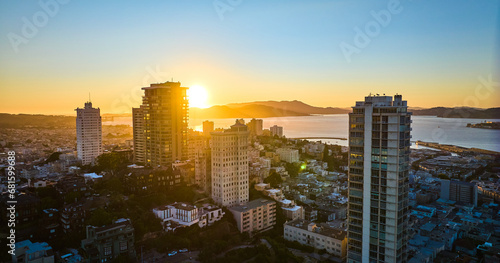 Aerial sun behind mountain seen through San Francisco skyscraper buildings at sunset  CA