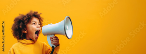 young boy in a yellow hoodie loudly announcing discounts and sales in a children's store through a megaphone photo