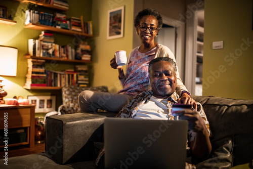 Senior couple online shopping with credit card from laptop at home photo