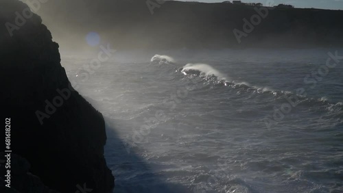 Huge waves hitting the cliff and exploding photo