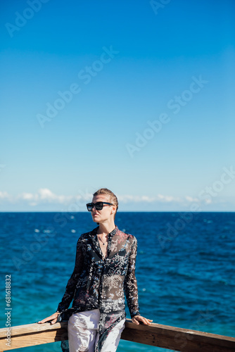 Beautiful slender woman walking in the park on the coast © dmitriisimakov
