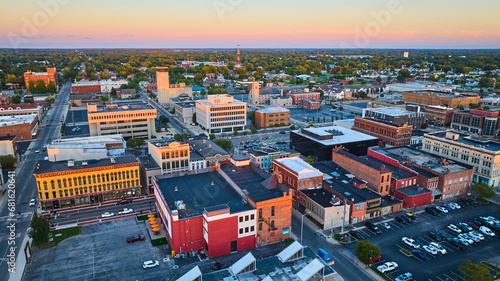 Midwest city downtown aerial at sunset, Muncie, Indiana with buildings and pink sky photo