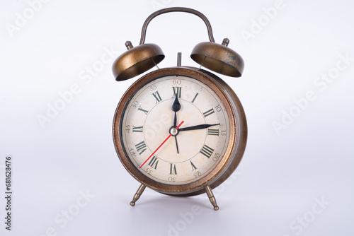 Metal bronze antique shabby vintage alarm clock on a white background
