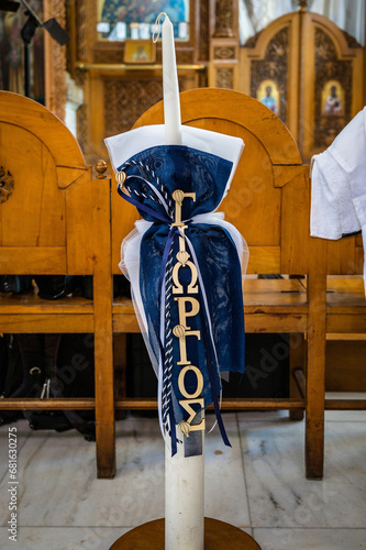 Elegant Decorated Altar Baptism Candle (Lampade) for Greek Orthodox Ceremony. Perfect for conveying the sanctity of religious ceremonies, cultural celebrations, and editorial content. Selective focus photo