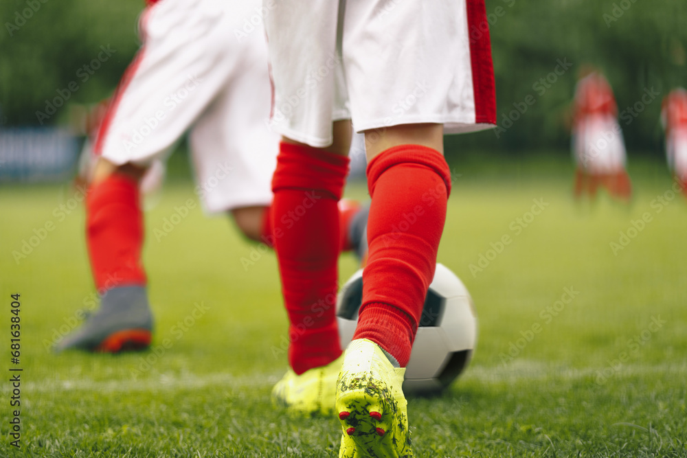 Obraz premium Boys attending soccer training on school field. Young multiracial football players at training camp. Soccer practice for children