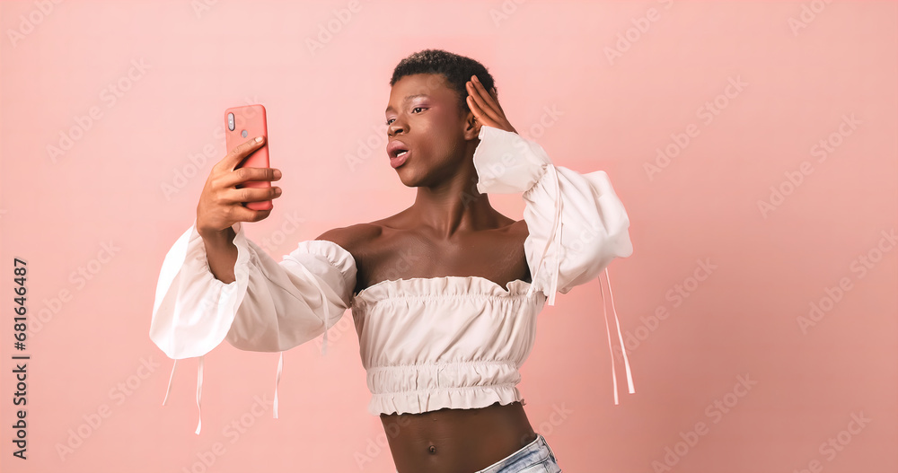 Φωτογραφία Selfie with phone of black transgender person in photo studio with pink backgrou