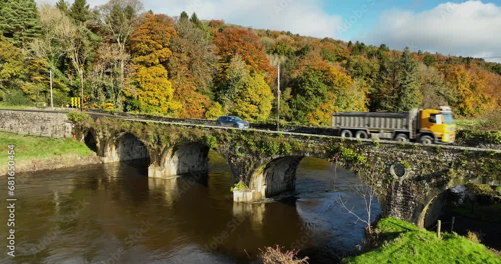 A truck drives across an old stone bridge over a river in 4k A truck drives across an old stone bridge over a river in 4k