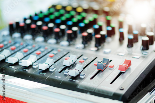 Sound mixer with orange flare at the audio control studio.