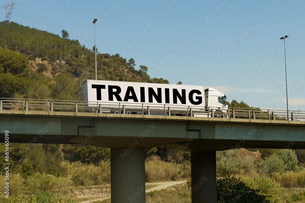 Fototapeta premium A truck is driving across the bridge, with the inscription on the trailer - TRAINING.