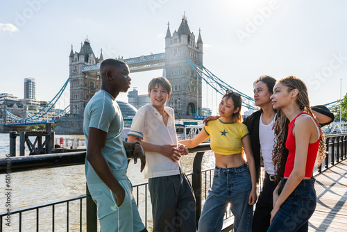 Multiracial group of happy young friends bonding in London city - Multiethnic teens students meeting and having fun in Tower Bridge area, UK - Concepts about youth lifestyle, travel and tourism © oneinchpunch