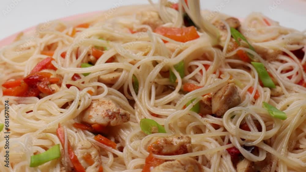 rice noodles with chicken and vegetables, rotation in circle. asian cuisine, Turning. selective focus. Take noodles with Chinese chopsticks rice noodles with chicken and vegetables, rotation in circle. asian cuisine, Turning. selective focus. Take noodles with Chinese chopsticks