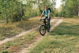 An active lifestyle.A cyclist with a backpack on a mountain bike rides along a forest road in autumn
