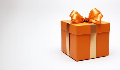 Orange gift box isolated - golden ribbon - copy space to the left