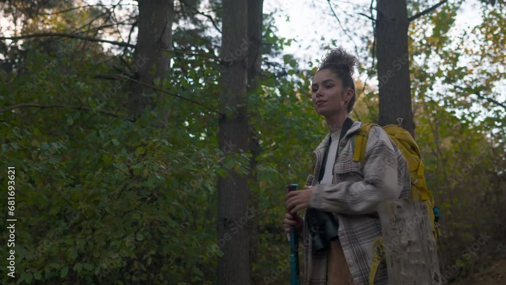 A curly-haired forest wanderer, enjoying the serene atmosphere of an autumn forest trail, accompanied by her trusty binoculars. A curly-haired forest wanderer, enjoying the serene atmosphere of an autumn forest trail, accompanied by her trusty binoculars.